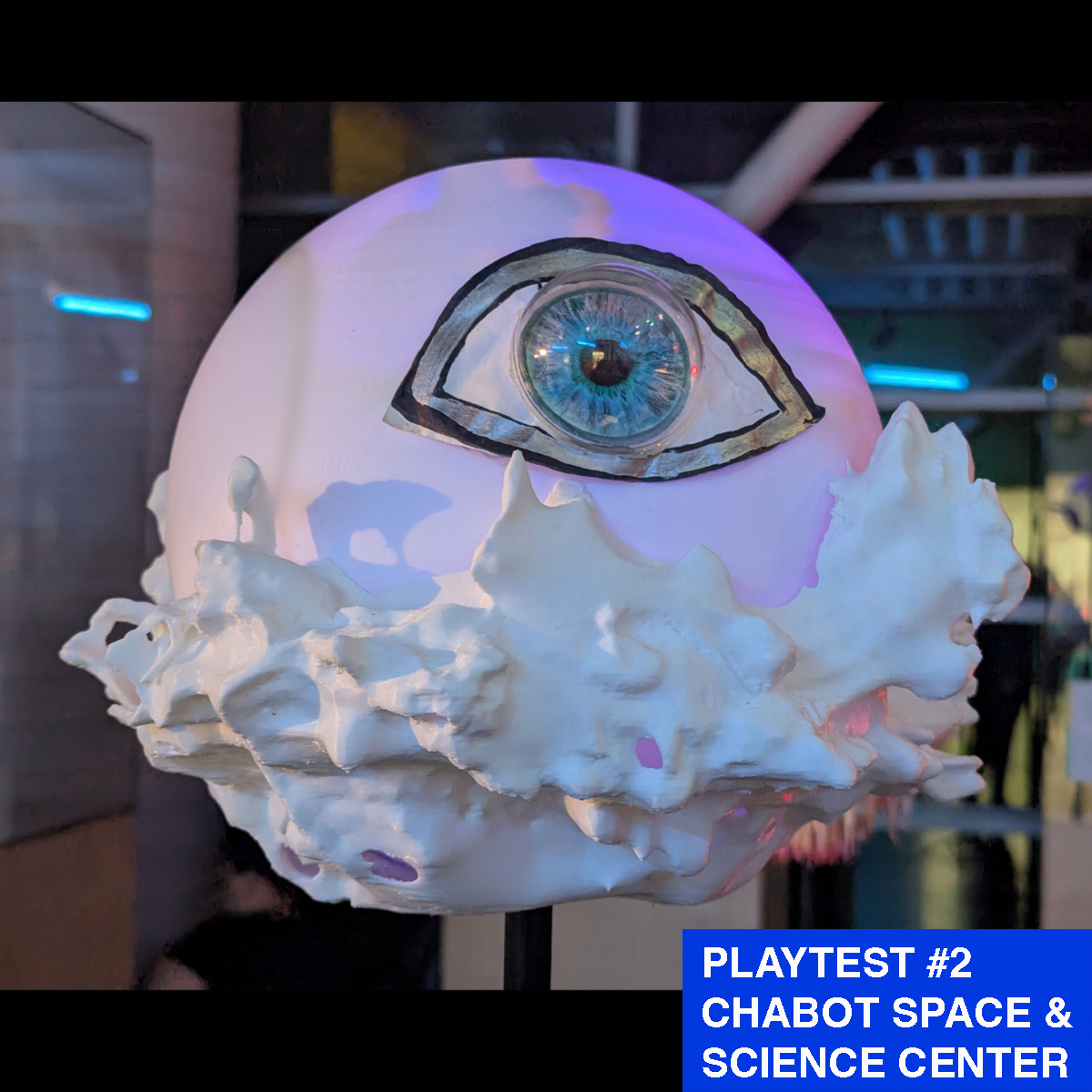 A planet sculpture that has a large eye on the side